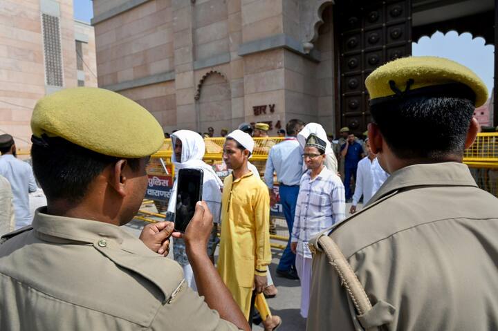 Police personnel use mobile phones to conduct a video-graphic survey outside Gyanvapi Masjid in Varanasi. (Source: PTI)