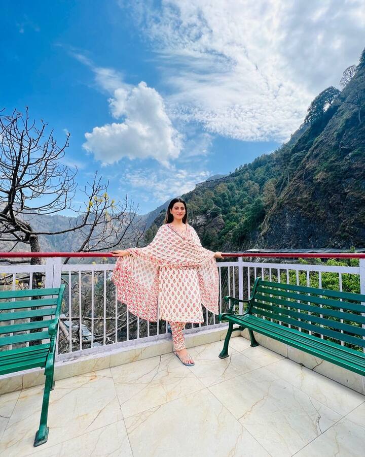 तस्वीरों में अक्षरा सिंपल रेड और व्हाइट सूट में पहाड़ों के बीच तस्वीरें खिंचवा रही हैं.