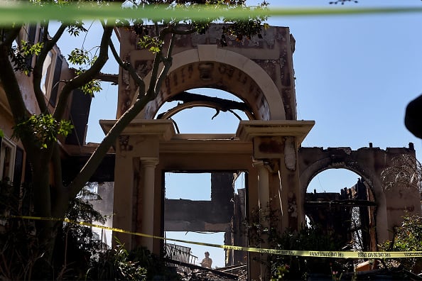A firefighter works to put out hotspots at one of over 20 homes destroyed by the Coastal fire in Laguna Niguel, California. The brush fire was fueled by windy and dry conditions amid California’s severe drought which has been compounded by climate change. (Source: Getty Images)