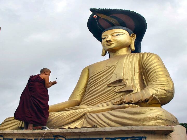 A Buddhist monk lights candles in front of a Buddha statue on the occasion of Buddha Purnima festival, in Agartala, Monday, May 16, 2022. (PTI Photo)