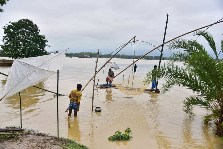 Villagers fish in a flood-affected area following heavy rains in Hojai district of Assam. (Image Source: PTI)