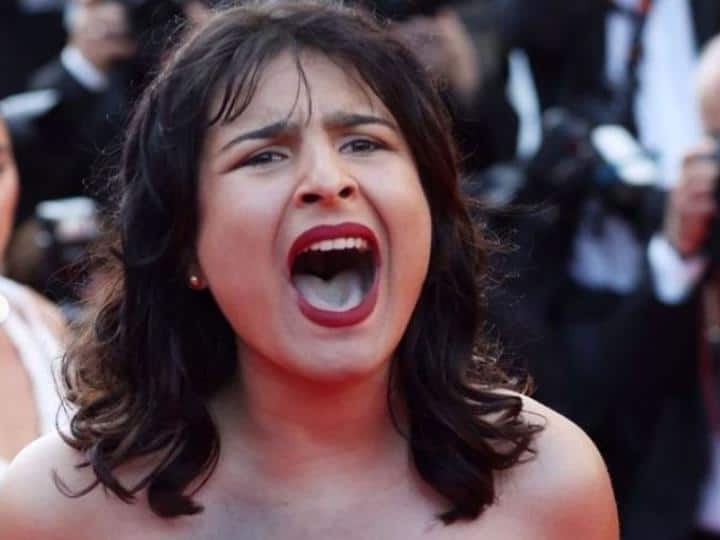 Cannes 2022: कांस में रेड कार्पेट पर टॉपलेस होकर यूक्रेनी महिला जताया विरोध, "स्टॉप रेपिंग अस" के लगाए नारे