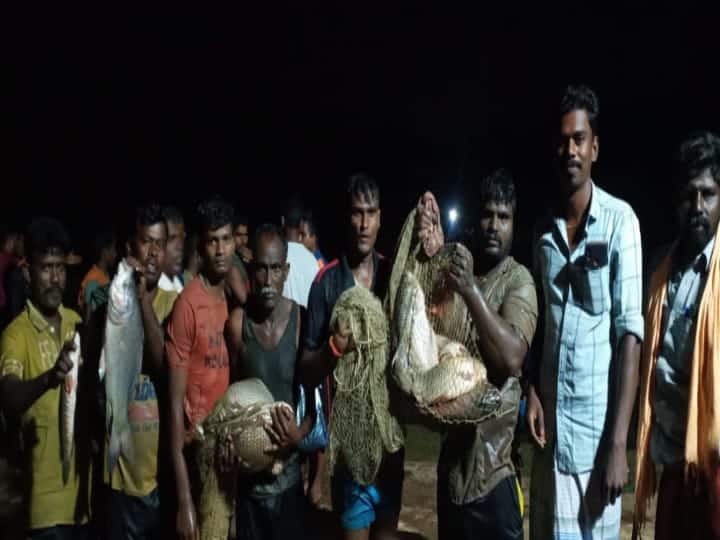 வலையில் சிக்கிய மீன்களுடன் கிராம மக்கள் போஸ்.