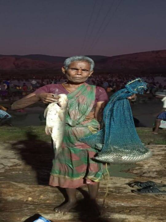 தனது வலையில் சிக்கிய மீனுடன் உற்சாக போஸ்கொடுக்கும் மூதாட்டி.