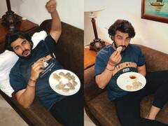 Arjun Kapoor Photos: सोफे पर आराम फरमाते हुए मोमोज खाते दिखे अर्जुन कपूर, चीट डे को एक्टर ने किया खूब एंजॉय