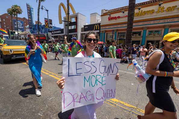 In the wake of multiple incidents of mass shootings in the country, a woman protests gun violence during the LA Pride Parade on Hollywood Boulevard. Image Source: Getty Images