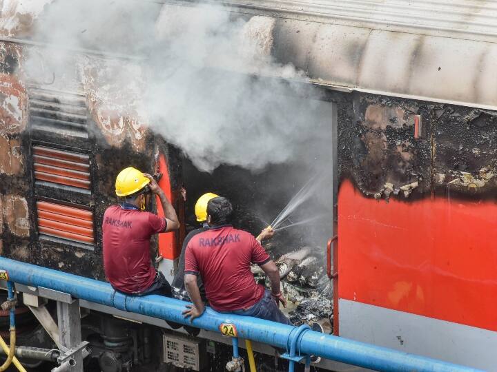 सिकंदराबाद में अभ्यर्थियों ने प्रदर्शन के दौरान ट्रेन में लगाई गई आग को बुझाते रेलवे कर्मचारी.