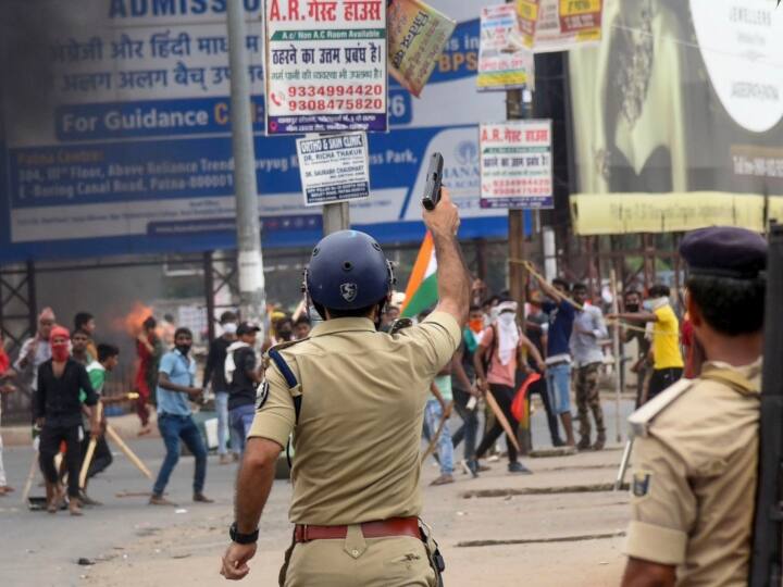 दानापुर में आगजनी कर रहे प्रदर्शनकारियों को नियंत्रित करने की कोशिश करते पुलिसकर्मी.