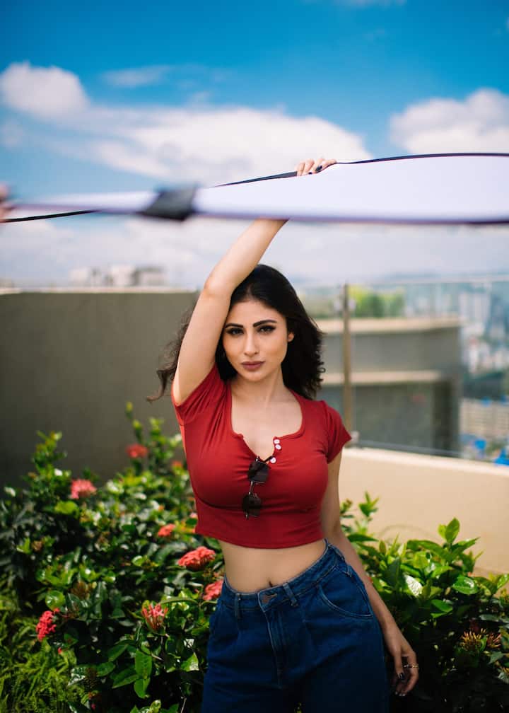 She paired her top with a classic navy blue denim. Mouni was posing around flowers and leaves.