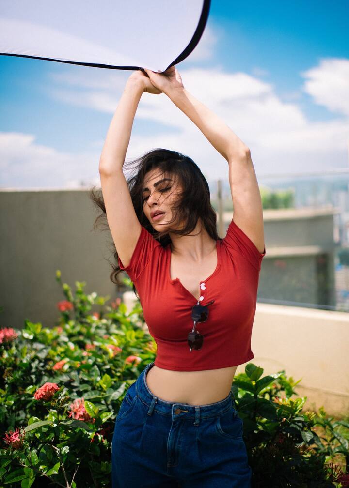 For the picture session, she held a reflector in her hand under the clear sky.