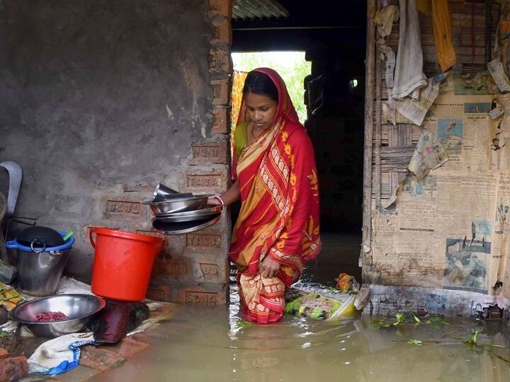 A woman at her flooded house at Nagendra Nagar in Karimganj district. Five more people lost their lives in the deluge and the number of affected people has risen to 24.92 lakh. (Source: PTI)