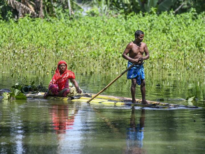 Villagers use a banana raft to cross a flooded field at a village in Nagaon. Brahmaputra, Beki, Kopili, Barak and Kushiyara rivers were flowing above the danger level in some places. Farmlands over 85,673.62 hectares of land are still inundated, while 4,304 animals have been washed away. (Source: PTI)