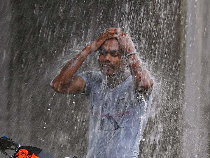 A youth cools himself with rain water during heavy monsoon shower in New Delhi. The IMD has issued an orange alert, warning of moderate rainfall in the city on June 30. (PTI Photo)