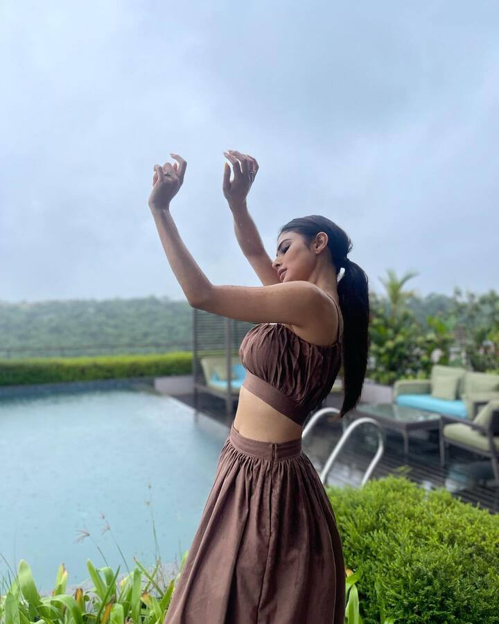 చేతులు రెండూ పైకెత్తుతూ ఆమె తీయించుకున్న ఫోటోలు అర్థం కాక అభిమానులు తలలు పట్టుకుంటున్నారు. -Image Credit:Mouni Roy/Instagram