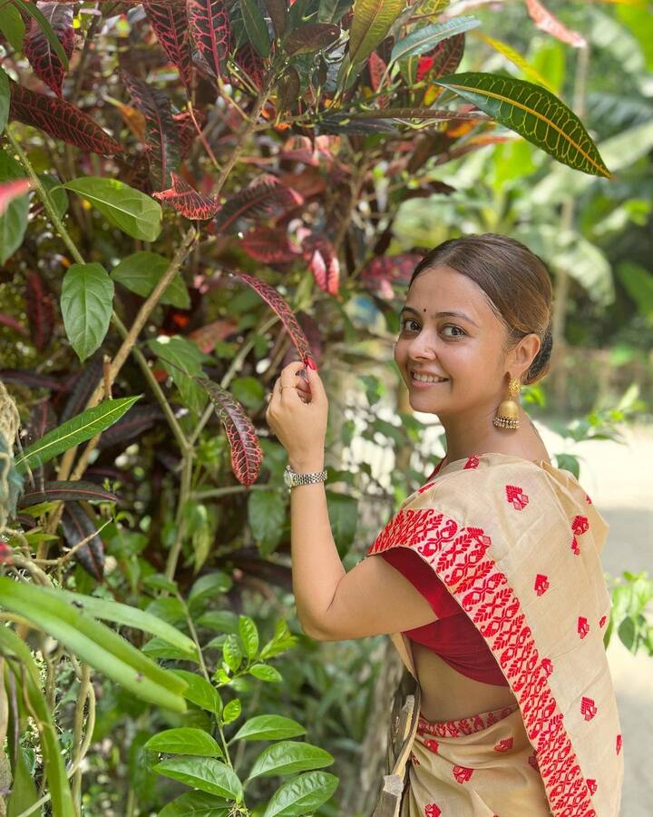 तस्वीरों में देवोलीना भट्टाचार्जी को असमिया लुक में देखा जा सकता है. वह फेडेड येलो और रेड कलर की साड़ी पहनी है, जिसे उन्होंने रेड सिंपल ब्लाउज के साथ पेयर किया है.