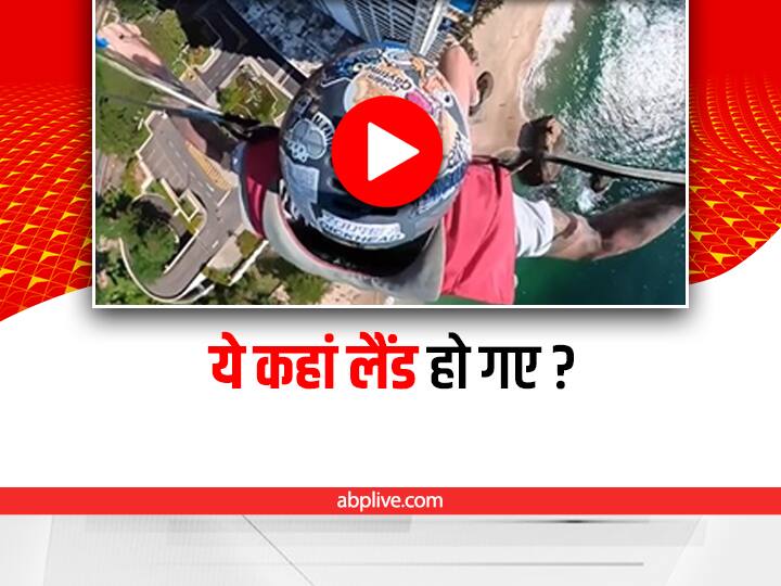 person wearing parachute lands on wrong building video viral on social media Watch: पैराशूट से गलत बिल्डिंग पर हो गई लैंडिंग, सिक्योरिटी गार्ड के बोलने पर ऐसे वापस लौटा शख्स