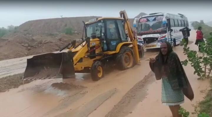 జయశంకర్ భూపాలపల్లి జిల్లాలో వరదలో చిక్కుకున్న ప్రైవేట్ ట్రావెల్స్ బస్సును జేసీబీతో లాగుతున్న పోలీసులు.