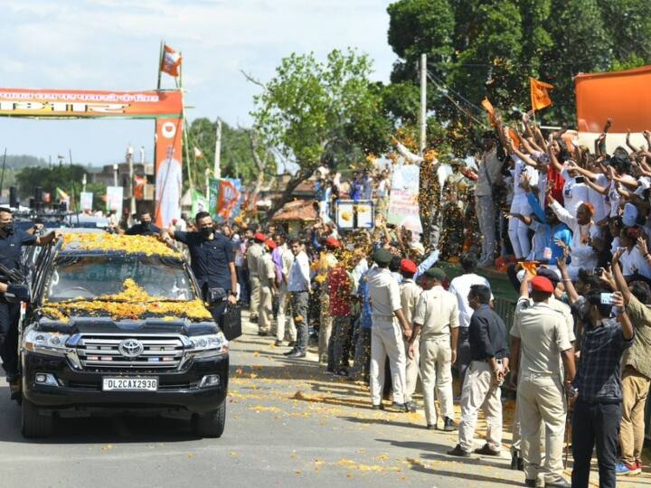 जिनमें से अधिकतर ने भगवा कपड़े पहन रखे थे. मोदी भीड़ की ओर हाथ हिलाकर और हाथ जोड़कर लोगों का अभिवादन कर रहे थे.