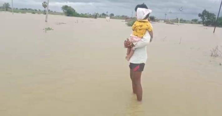 तापानं फणफणलेल्या मुलाला कडेवर घेऊन बापाने पुरातून वाट काढली.