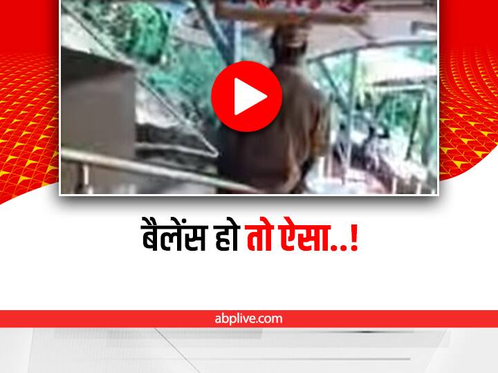 man came down from the railing of the stairs with luggage on his head video viral Watch: सिर पर सामान और गजब का बैलेंस, सीढ़ियों की रेलिंग से ऐसे उतरा ये शख्स