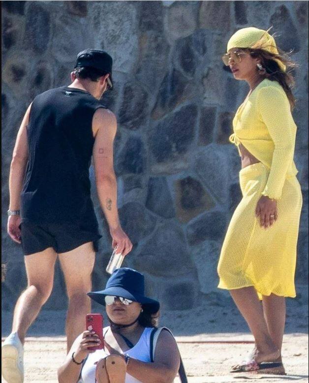 Priyankas accessoried with a yellow head scarf while Nick Jonas contrasted his outfit in all black