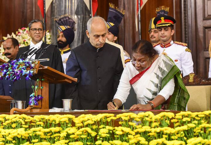 President Droupadi Murmu signs a register after taking oath in the Central Hall of Parliament, in New Delhi.  Murmu has made a special identity in public life by spreading awareness about education in tribal society and serving the public for a long time as a public representative. Image Source: PTI