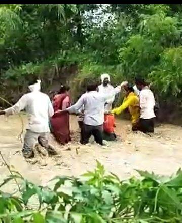 पुराच्या पाण्यातून वाट काढताना  शेतकऱ्यांची जीवघेणी कसरत