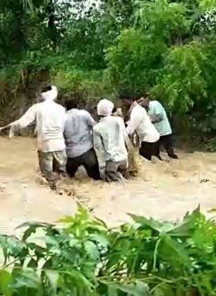 शेतकऱ्यांनी बैलगाडी घेऊन पुराच्या पाण्यातून प्रवास केला