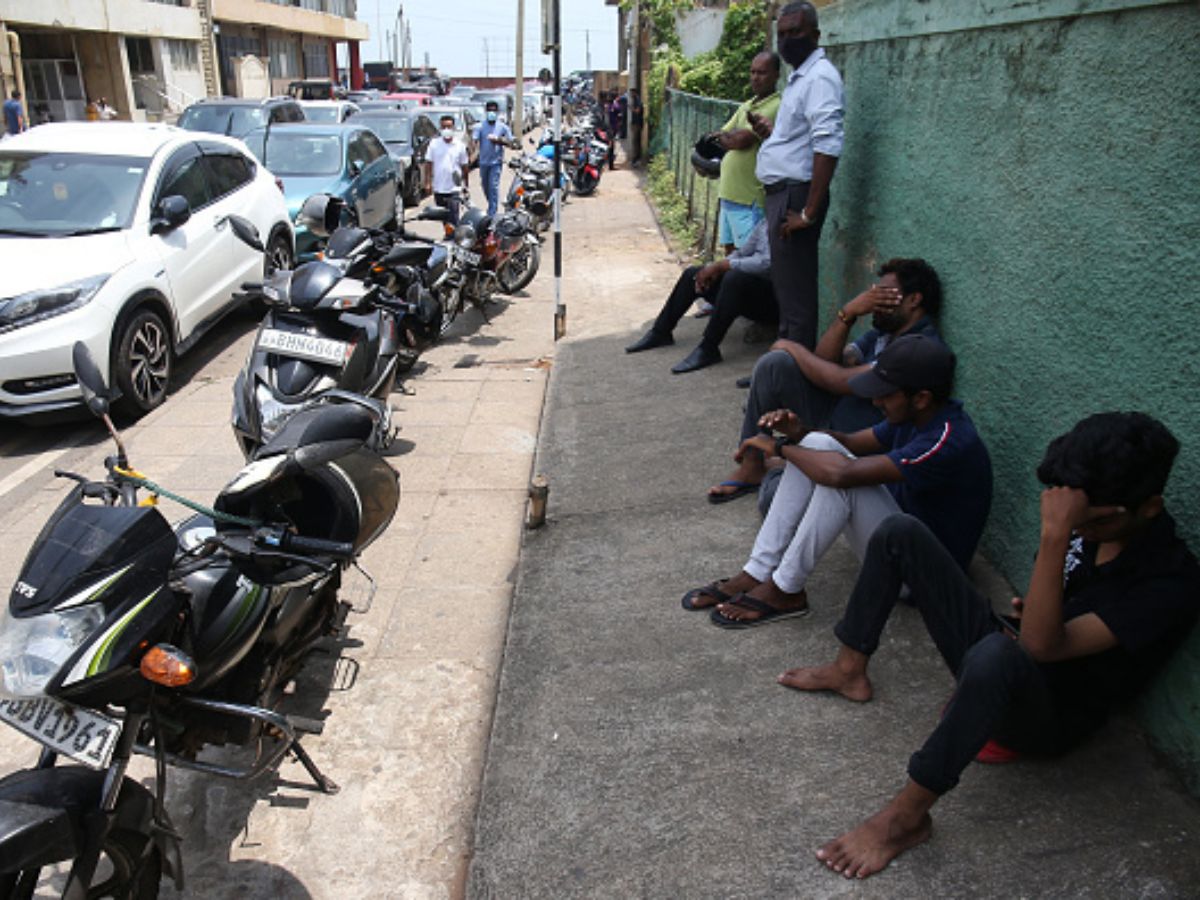 People sit in a queue on the side of the road waiting to buy petrol in Colombo, Sri Lanka.  Photo: Getty