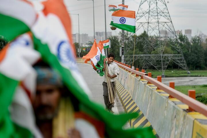 Workers install national flags on the guard rails of an elevated road in Ghaziabad as part of 'Har Ghar Tiranga' campaign, ahead of Independence Day celebration. (Image Source: PTI)
