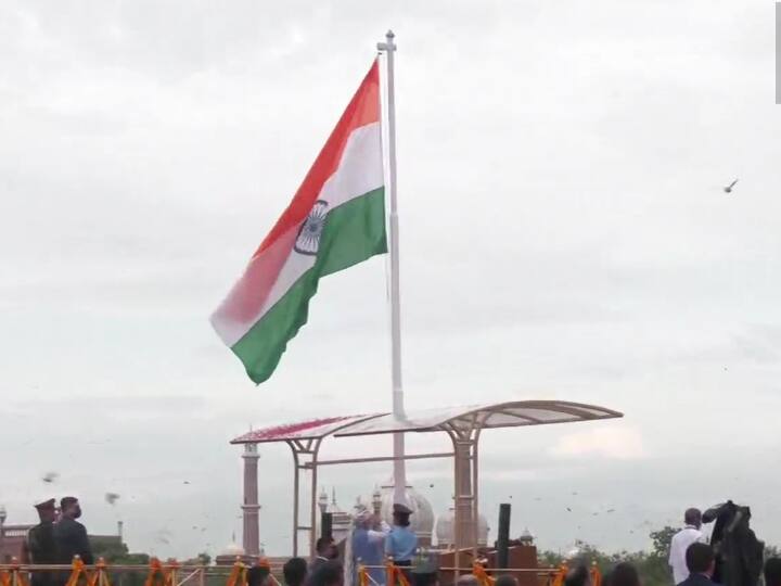 Prime Minister Narendra Modi hoists the national flag, flower petals shower down as it unflurs. (ANI Photo)