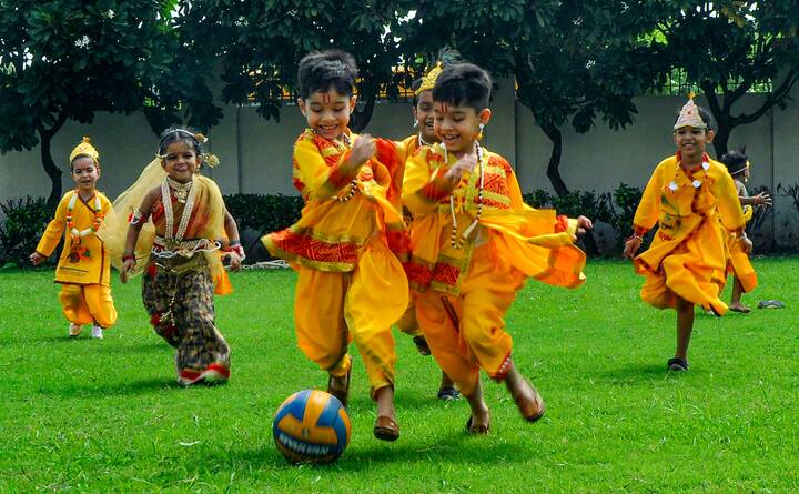 Students dressed up as Lord Krishna and Goddess Radha play football during 'Janmashtami' celebrations, at a school in Patiala. (Image: PTI)