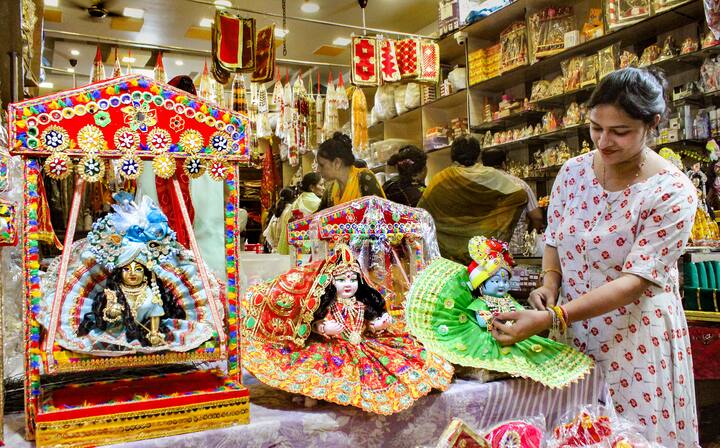 গুরগাঁওতেও একই ছবি। জন্মাষ্টমীর আগে জমে উঠেছে কেনাকাটা। রয়েছে কৃষ্ণের হরেক সাজের প্রতিমা। পছন্দমতো প্রতিমা বেছে নিচ্ছেন এক ভক্ত। ছবি: পিটিআই