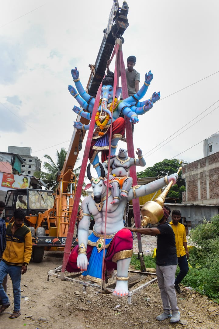 An idol of Lord Ganesha being lifted by a crane for transportation ahead of the 'Ganesh Chaturthi' festival in Maharashtra's Solapur. (Image: PTI)