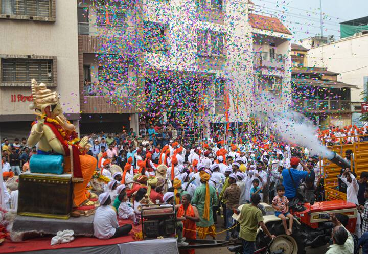 Devotes carry an idol of Lord Ganesha during a procession ahead of Ganesh Chaturthi festival in Karad, Maharashtra. (Image: PTI)