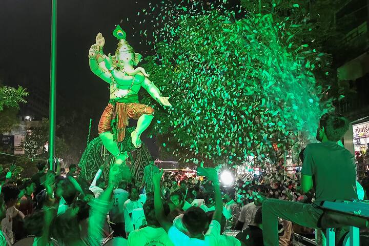 Devotes carry an idol of Lord Ganesha during a procession ahead of Ganesh Chaturthi festival in Surat, Gujarat. (Image: PTI)