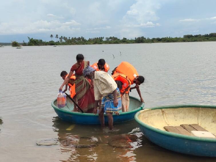 Villagers cross the river in Parisals after a footbridge was submerged in floods in Coimbatore TNN கோவை: வெள்ளத்தில் மூழ்கிய தரைப்பாலம்; பரிசல்களில் ஆற்றைக் கடக்கும் கிராம மக்கள்