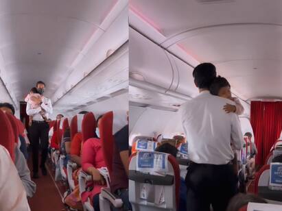 flight attendant console crying baby in flight video goes viral Watch Video: கண்ணா நீ தூங்கடா!! விமானத்தில் அழுத குழந்தை! நடந்து நடந்து அரவணைத்த ஊழியர் - க்யூட் வீடியோ!