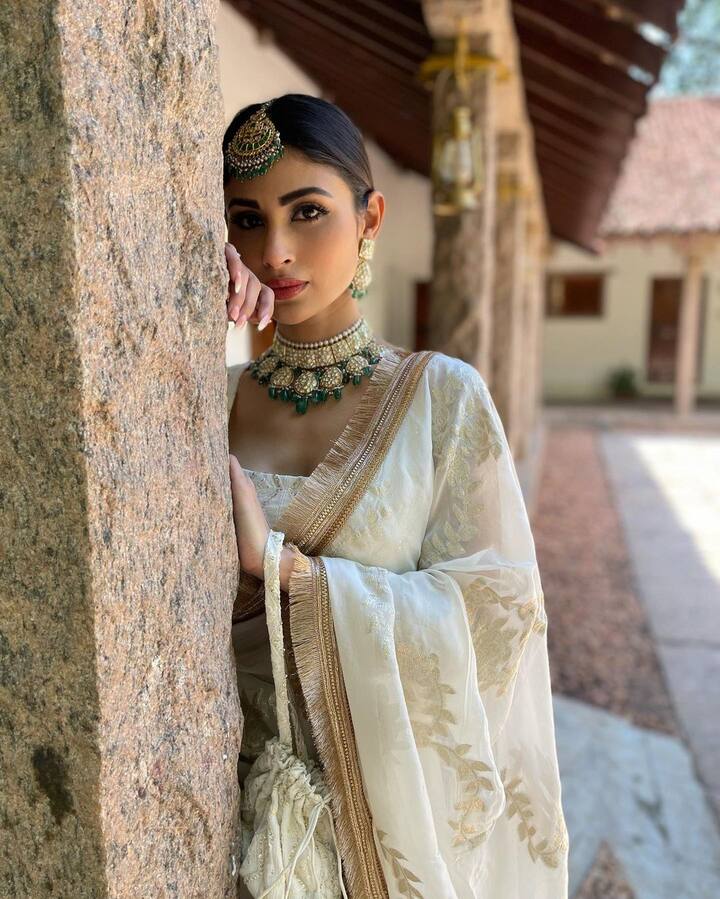 फोटोंमध्ये मौनी पांढऱ्या रंगाचा लेहेंगा परिधान करताना दिसत आहे. यासोबत तिने मॅचिंग ब्लाऊज आणि दुपट्टा घेतला आहे.(फोटो सौजन्य :imouniroy/इंस्टाग्राम)