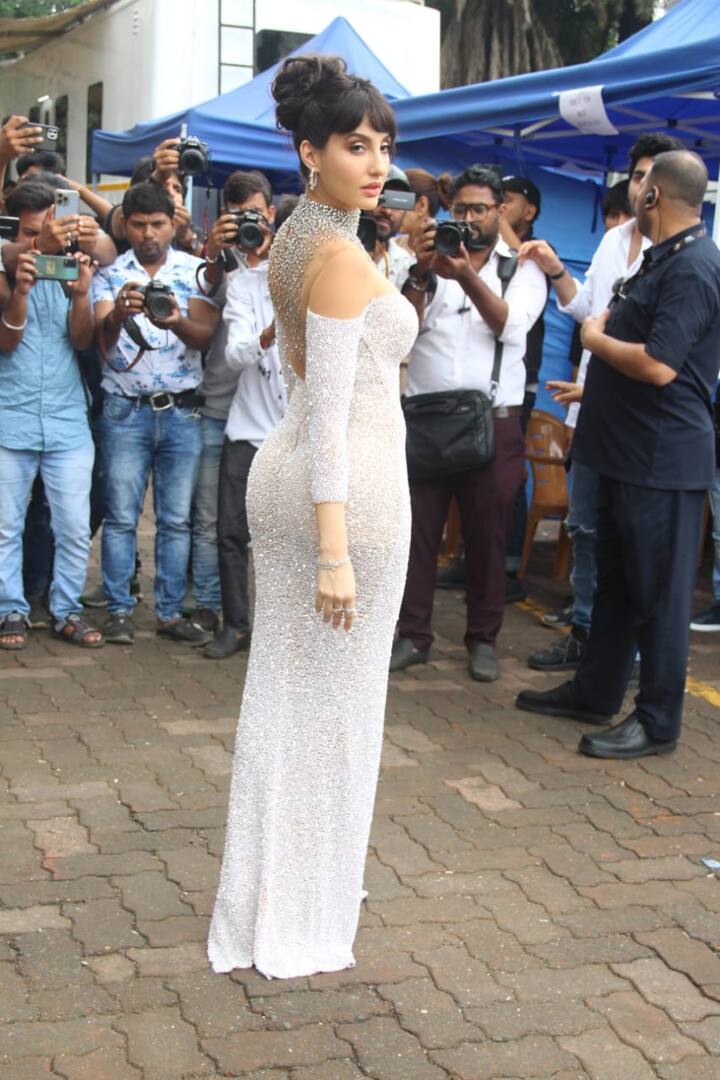 तस्‍वीरों में नोरा को एक शिमरी थाई हाई स्लिट गाउन में देखा जा सकता है. उनका ये आउटफिट जितना स्‍टाइलिश है, नोरा उतनी ही उसमें ग्‍लैमरस लग रही हैं.