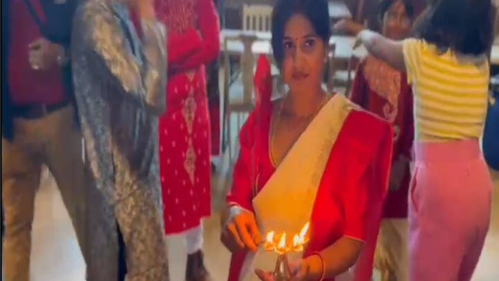 আরতি শেষে পঞ্চপ্রদীপ হাতে পুজো এক সদস্যা। পরনে বাঙালির ট্রেডমার্ক লালপাড় সাদা শাড়ি। ছবি সূত্র: পুজো কমিটি