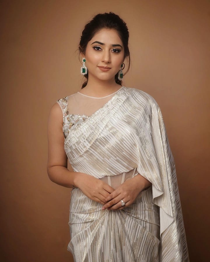 शिमरी आय मेकअप, न्यूड लिपस्टिकसोबत डायमंड इअररिंग्समुळे हा लूक उठून दिसत आहे.