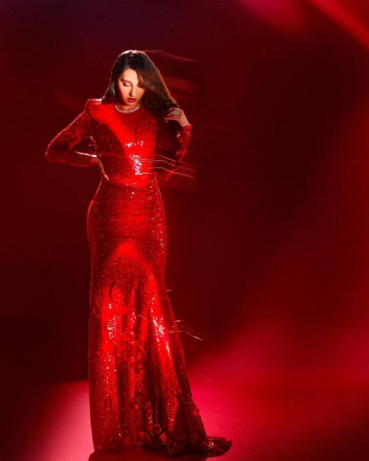 नोराने नुकतेच तिचे काही फोटो इंस्टाग्रामवर शेअर केले आहेत. यामध्ये ती लाल रंगाच्या फुल स्लीव्हज सिक्वेन्स्ड गाऊनमध्ये दिसत आहे.  (फोटो सौजन्य : norafatehi/इंस्टाग्राम)