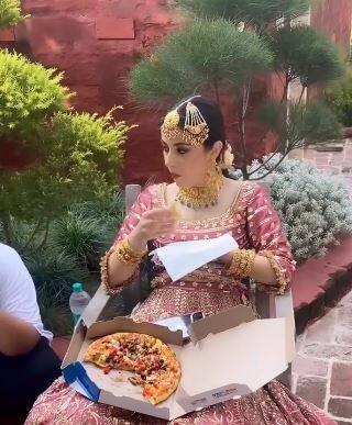 This bride could not give up the temptation of pizza even on the wedding day, feasted like this in a bridal dress ਲਾੜੀ ਵਿਆਹ ਵਾਲੇ ਦਿਨ ਵੀ ਪੀਜ਼ਾ ਦਾ ਲਾਲਚ ਨਹੀਂ ਛੱਡ ਸਕੀ, ਦੁਲਹਨ ਦੇ ਪਹਿਰਾਵੇ 'ਚ ਇੰਝ ਕੀਤੀ ਦਾਵਤ