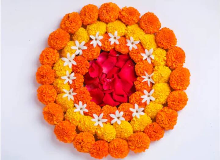झेंडूच्या फुलांच्या माळांनी तयार केलेली  ही रांगोळी झटपट काढून होते.