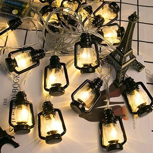 Lantern Black Shape Fairy String Lights: अगर मिट्टी के तेल वाले लालटेन को पसंद करते है और अपने घर को इससे ही बेहतरीन लुक देना चाहते है, तो ये लाइट्स खास आपके लिए ही है. इन लाइट्स को आप अमेजन पर 356 रुपये की कीमत में खरीद सकते हैं. ये लाइट्स 4 मीटर लंबी है और इसमें 16 LED दी गई है.