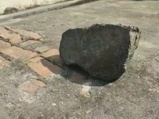 Pilibhit Stone Stones fell from sky on house house roof in Pilibhit in UP  ann | Pilibhit News: पीलीभीत में आसमान से गिरा गर्म और चमकीला पत्थर!  बाउंड्री वॉल धंसी, देखने के