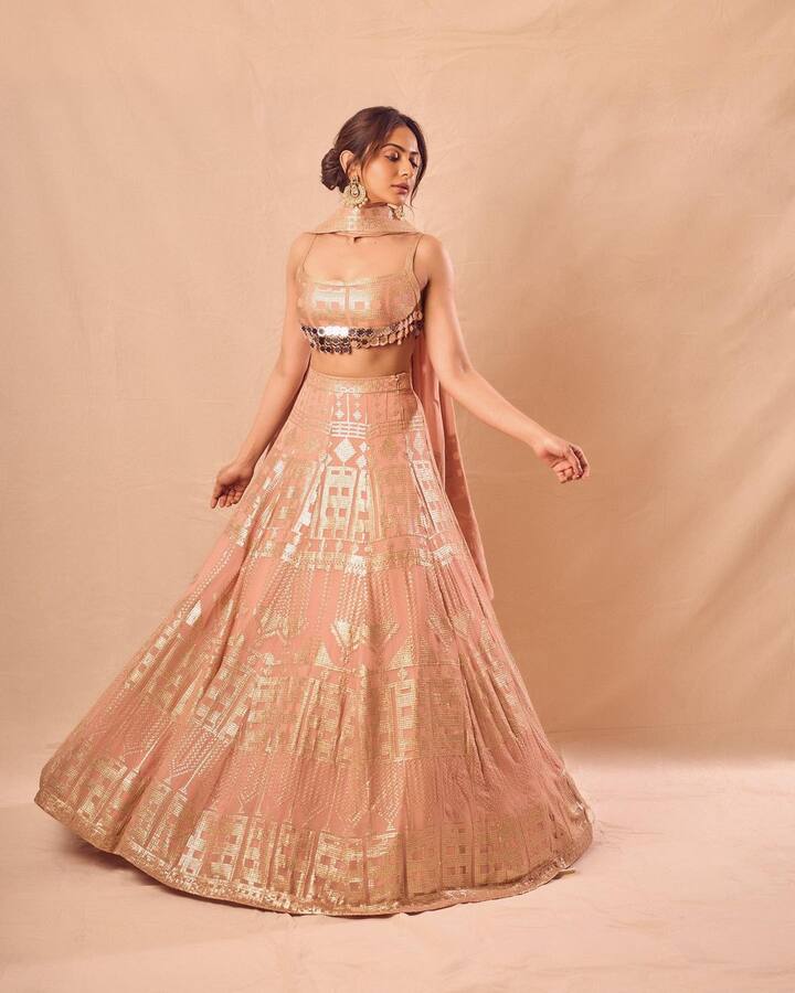 फोटोंमध्ये, रकुल पीच आणि गोल्डन वर्क असलेला सुंदर लेहेंगा परिधान केलेली दिसत आहे. येथे तिच्या ब्लाऊजने विशेषतः लोकांचे लक्ष वेधून घेतले आहे, ज्यामध्ये मिरर वर्कसह नक्षीकाम करण्यात आले आहे. (फोटो सौजन्य :rakulpreet/इंस्टाग्राम)