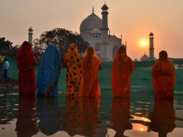 Devotees take part in a ritual to worship the sun on the banks of river Yamuna against the backdrop of Taj Mahal during the Hindu festival of Chhath Puja in Agra. (Source: AFP)