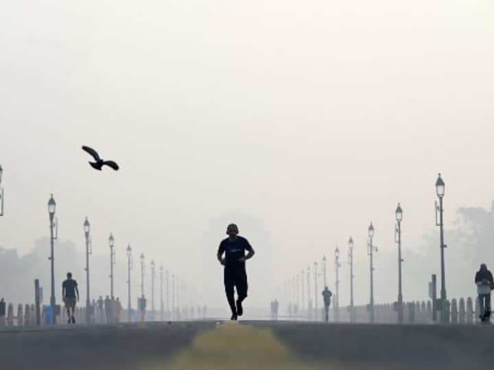 A man jogs along the road in front of India Gate as thick smog covers the national capital. (Source: AFP)